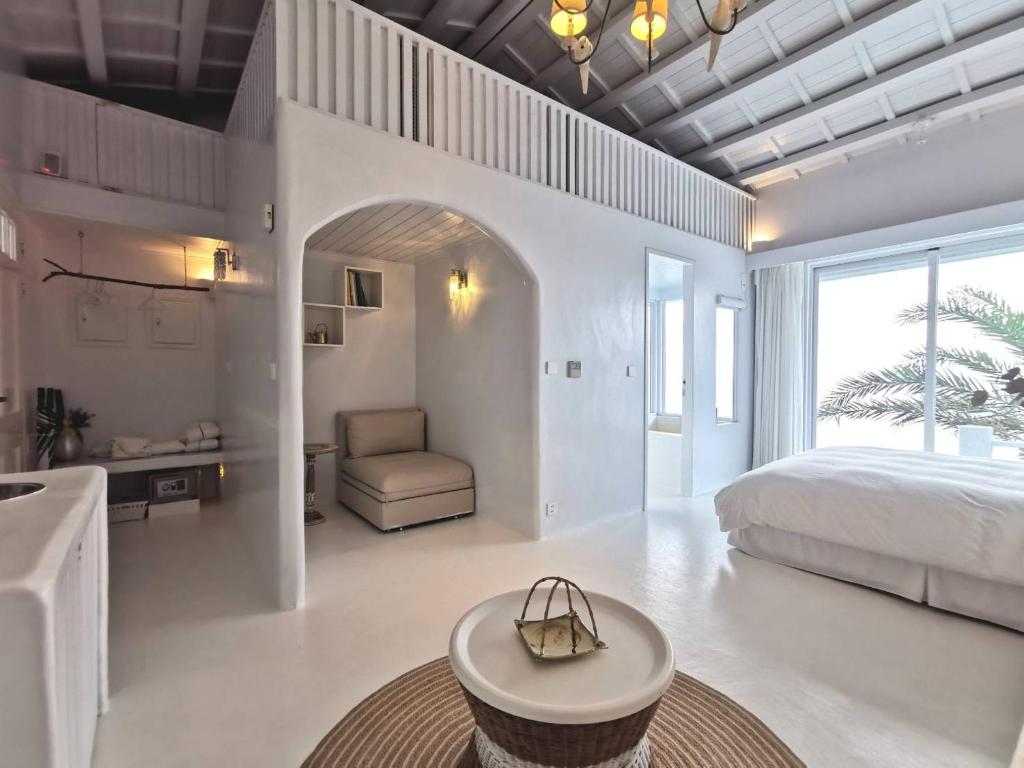 Un dormitorio con una cama, un sofá y una mesa. en Ample Villa 小希臘民宿, en Ruifang