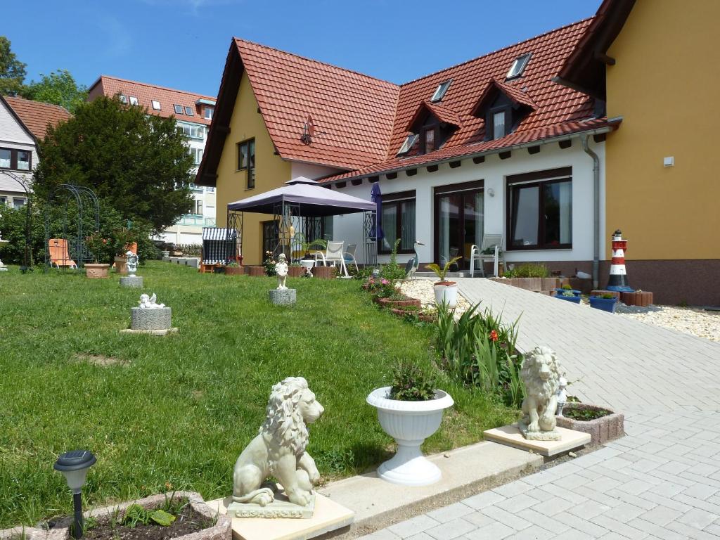ein Haus mit zwei Löwenstatuen auf einem Hof in der Unterkunft An der Uferpromenade in Worbis