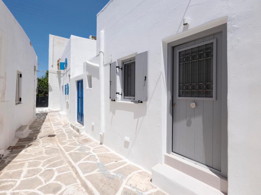 a narrow alley with white buildings and a door at M&M Parikia's Old Town Studio in Parikia