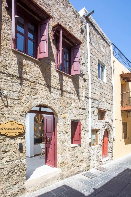 a stone building with pink doors and windows at Alexandras Stone House in Rhodes Town