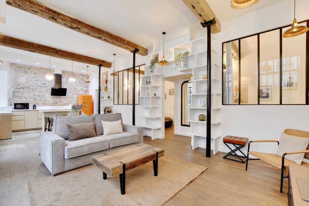un salon avec un canapé et une table dans l'établissement Magnifique loft 6P proche Bastille, à Paris