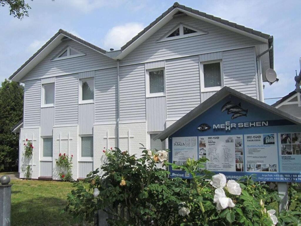 een wit huis met een bord ervoor bij House Thor - Huus Asgard in Nieby