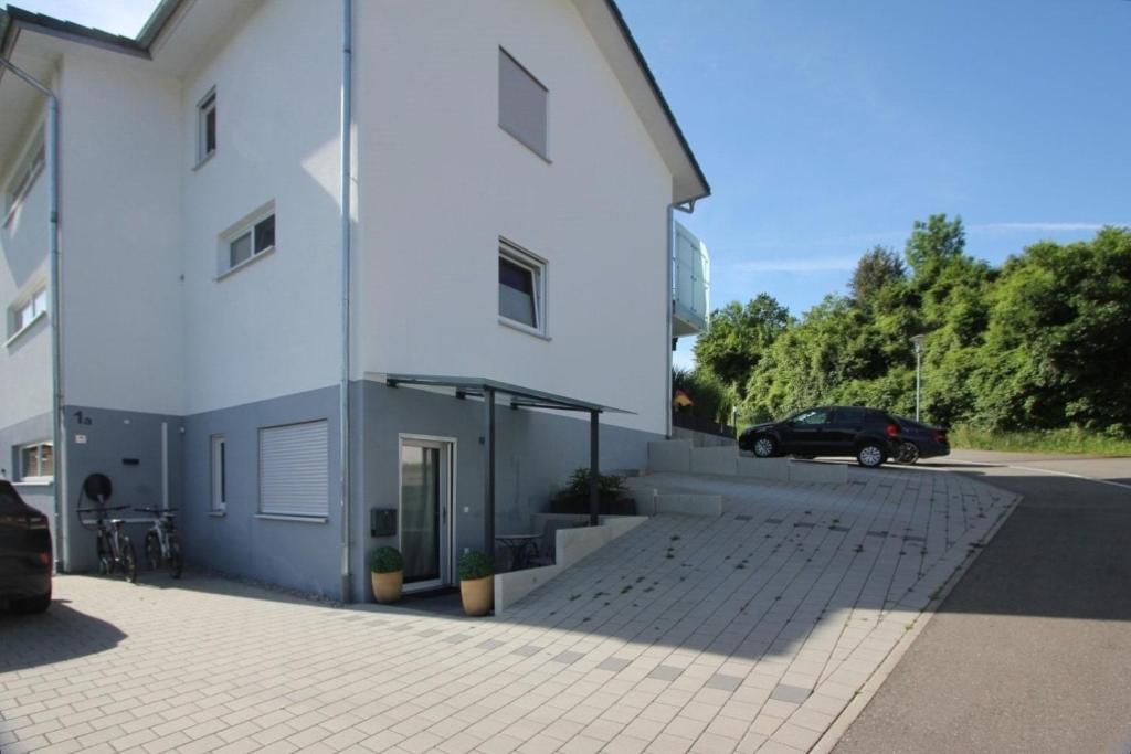 un edificio blanco con un coche aparcado al lado en Fewo Schlossbühl, en Meersburg