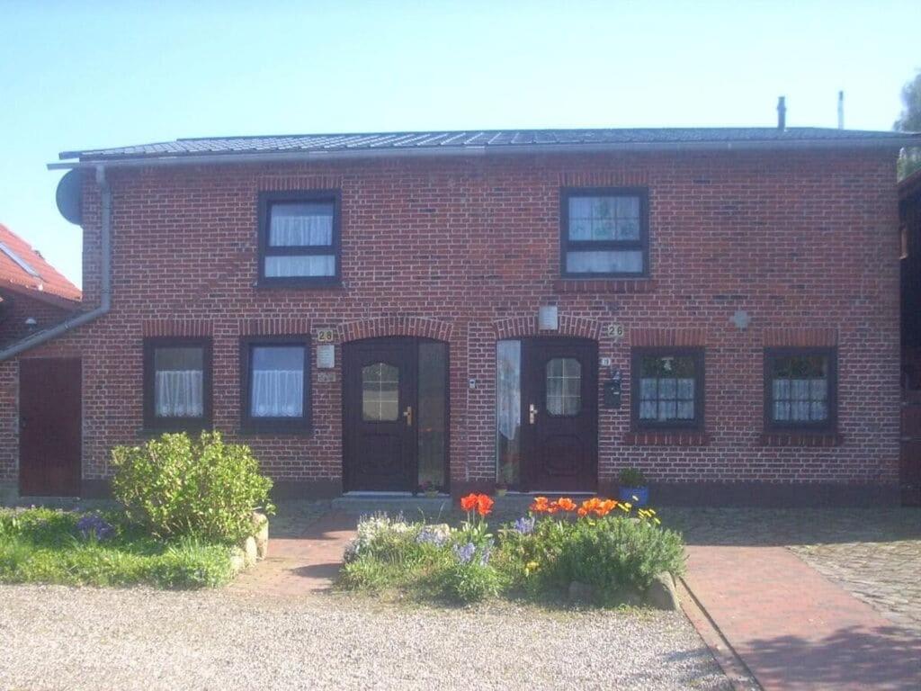 a brick house with flowers in front of it at Neeb Comfortable holiday residence in Gammendorf