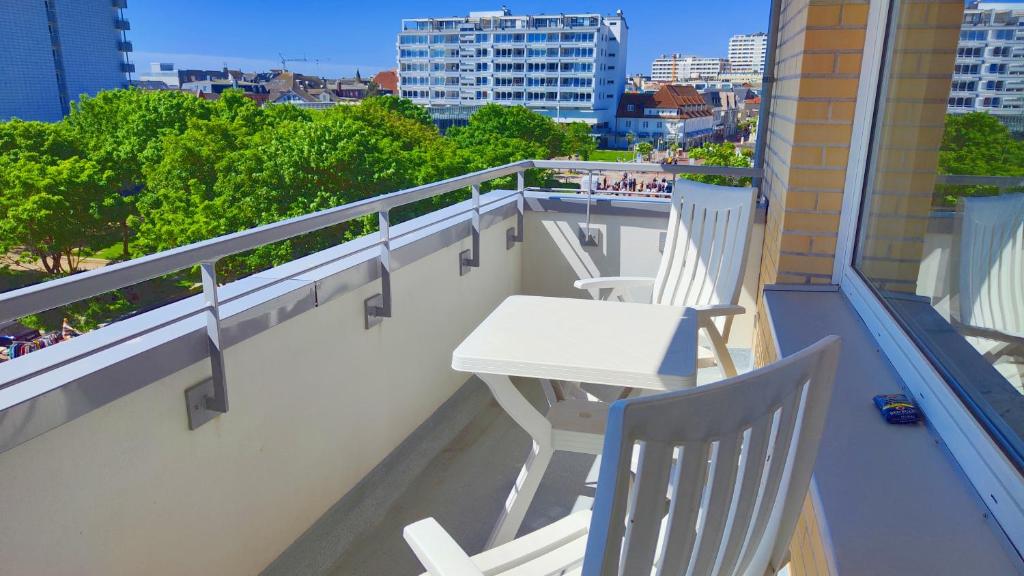 a balcony with two chairs and a table on a building at Sonne, Wind und Meer in Westerland
