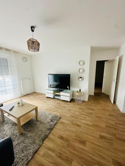 un salon avec une table et une télévision dans l'établissement Appartement spacieux et calme 20 min Champs Élysée, à Pierrefitte-sur-Seine