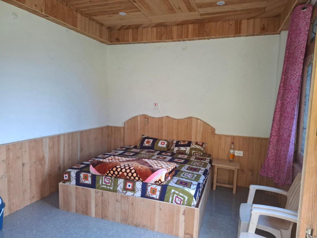 a bedroom with a bed with a wooden headboard at Paras Homestay in Shoja