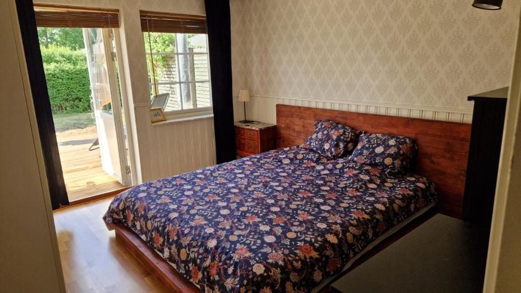 a bedroom with a bed and a sliding glass door at Blå rummet - Rum i familjärt boende - Sängkläder & handdukar ingår in Färjestaden