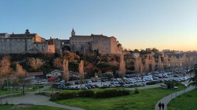 a bunch of cars parked in a parking lot with a castle at CASA FAUL con parcheggio vicino Alloggio turistico in Viterbo