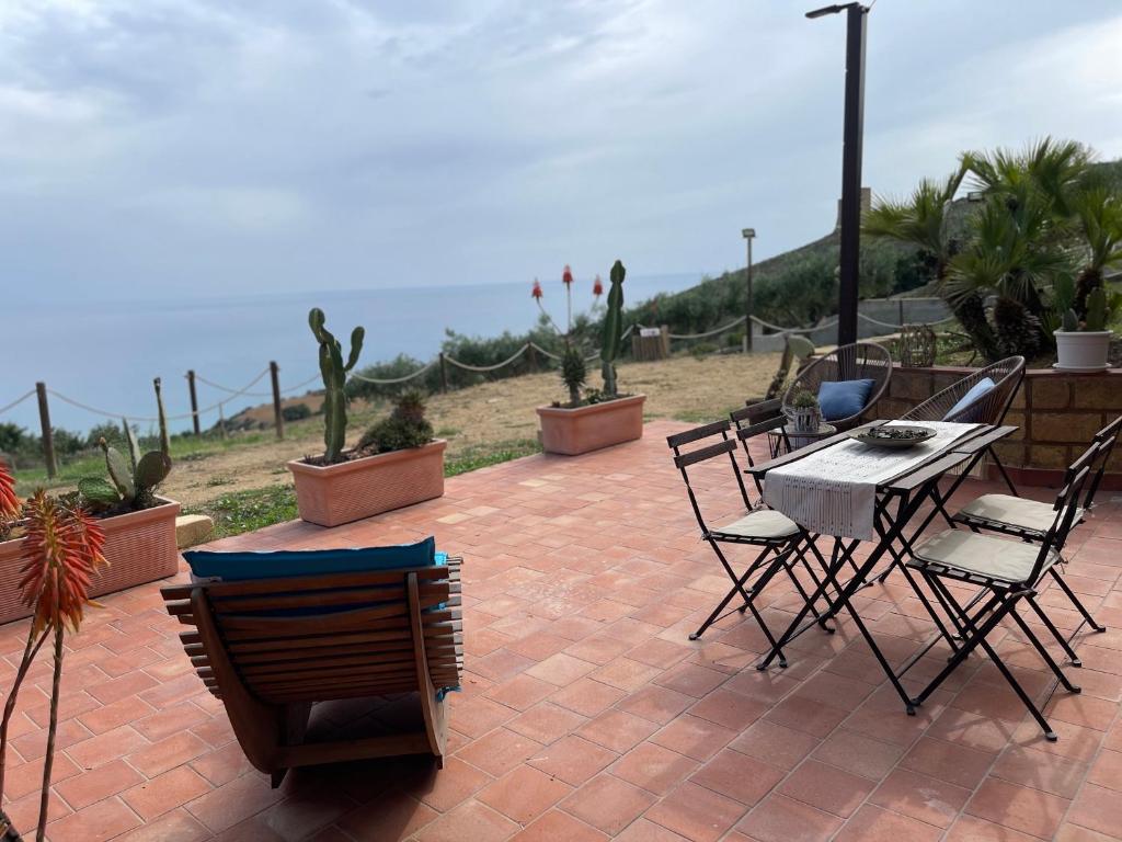 a patio with a table and chairs and cactus at B&B La Torre in Realmonte