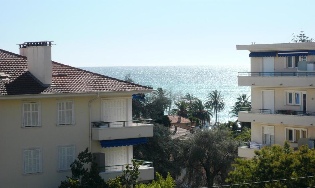 - une vue sur deux bâtiments et l'océan dans l'établissement Grand 2 pièces CLIMATISE, TERRASSSE VUE MER & PROCHE FETE DU CITRON, à Menton