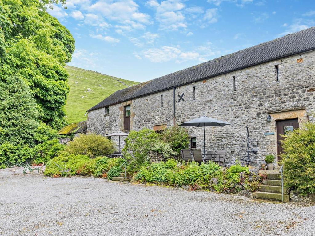 ハーティントンにある3 Bed in Hartington 62802の傘を前に置いた石造りの建物