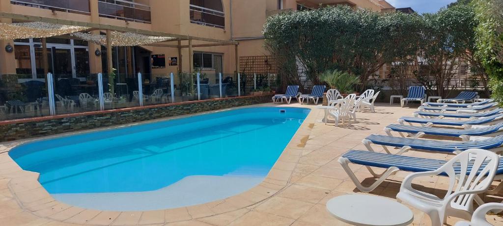 une piscine avec des chaises longues et un hôtel dans l'établissement Argelès 50 m plage, vue mer, à Argelès-sur-Mer