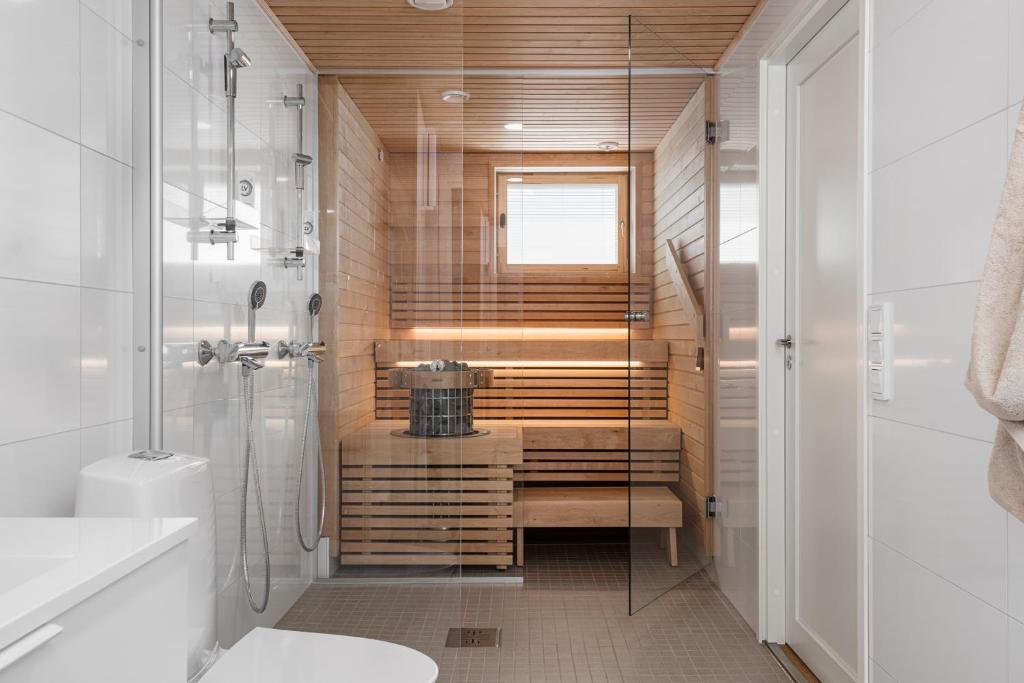 a bathroom with a shower and a toilet and a sink at Borg Katarina - Riverside View in Pori