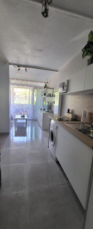 une cuisine avec une machine à laver dans une pièce dans l'établissement Jolie studio 4 couchages la grande motte, à La Grande Motte