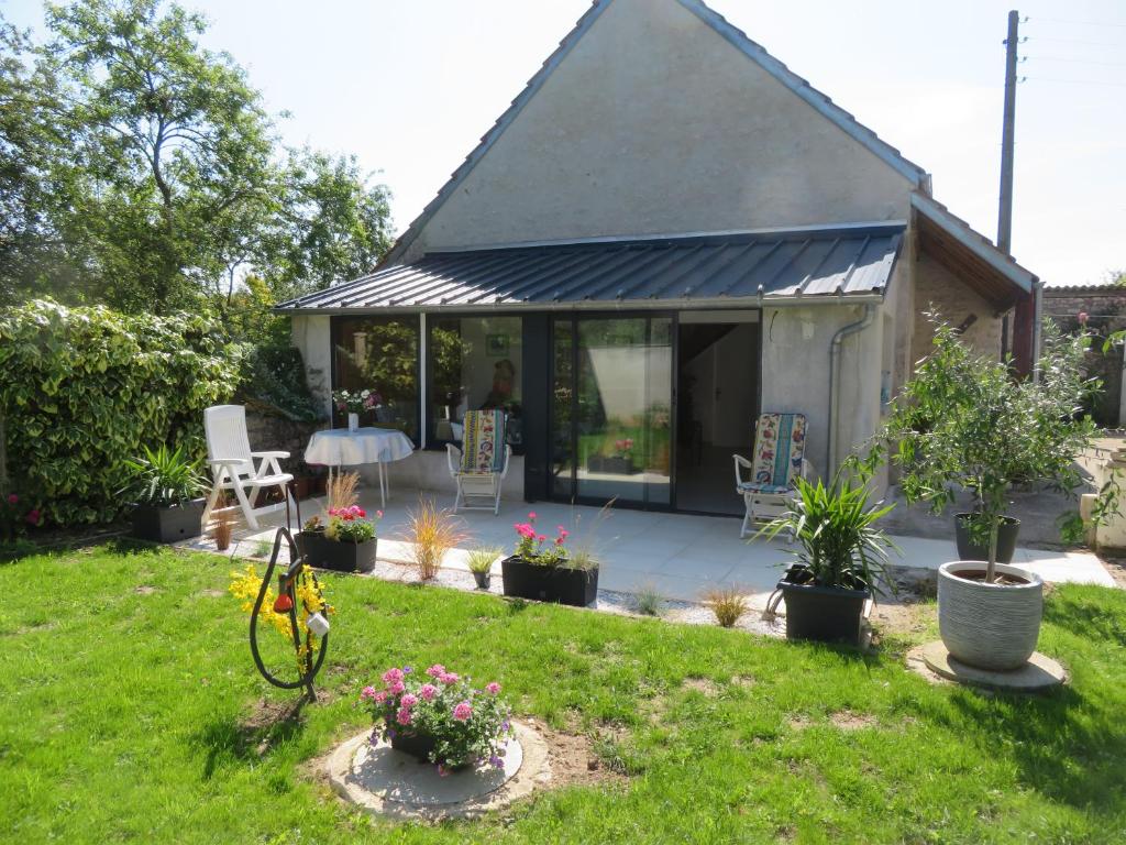a small house with a garden and a patio at La Glycine in Le Bardon