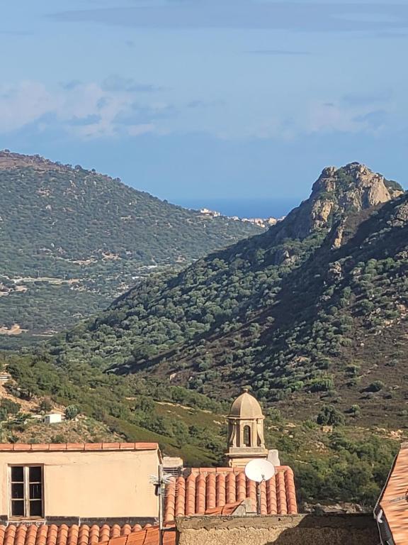 une vue d'un bâtiment avec une montagne en arrière-plan dans l'établissement La maison de corse, à Feliceto