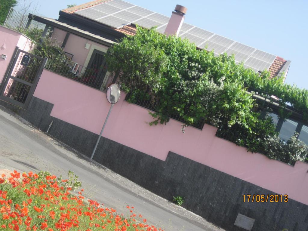 ein Haus mit einer rosa Wand mit Blumen darauf in der Unterkunft Scacciapensieri's home in Trecastagni