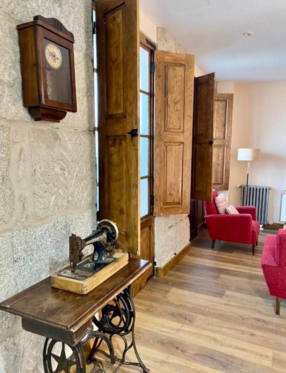 a room with a table and a clock on a wall at Casa San Amaro in San Amaro