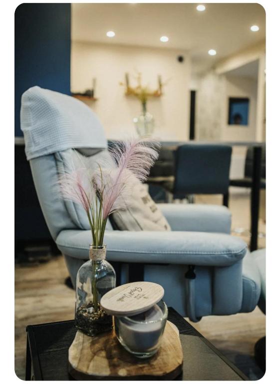 une chaise bleue et un vase avec des fleurs sur une table dans l'établissement Le Key Largo, à Cherbourg en Cotentin