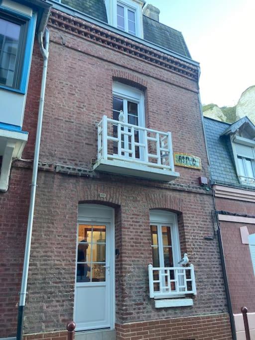 un bâtiment en briques avec un balcon avec un chat dessus dans l'établissement Villa Astrid le Tréport, au Tréport