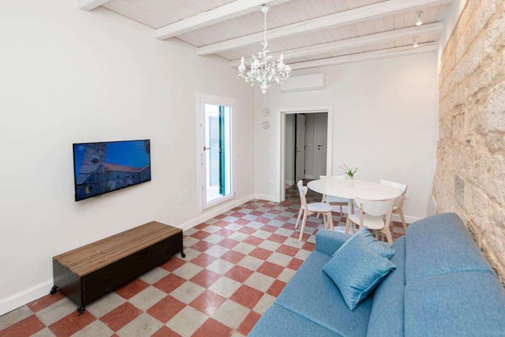 a living room with a blue couch and a table at Terrazza Nostromo Francesco in Trani
