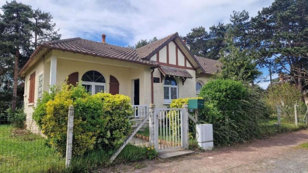 ein kleines Haus mit einem Zaun davor in der Unterkunft LouiseHélène in Merville-Franceville-Plage