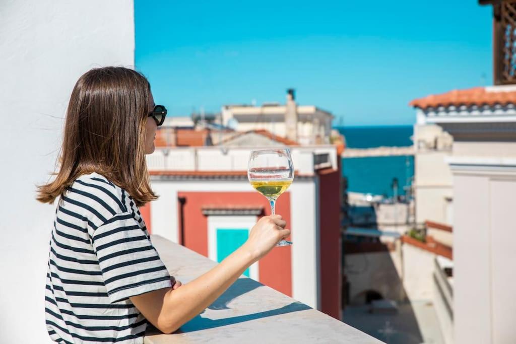 a woman holding a glass of wine on a balcony at Terrazza Nostromo Francesco in Trani