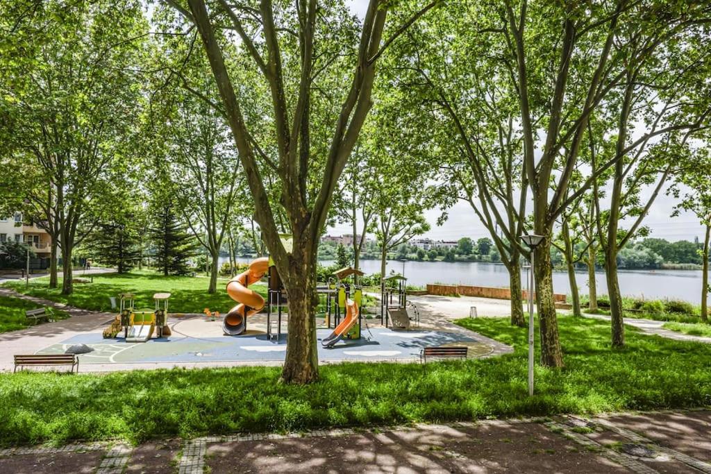 un parc avec une aire de jeux avec un toboggan et des arbres dans l'établissement Playground Suite, à Créteil