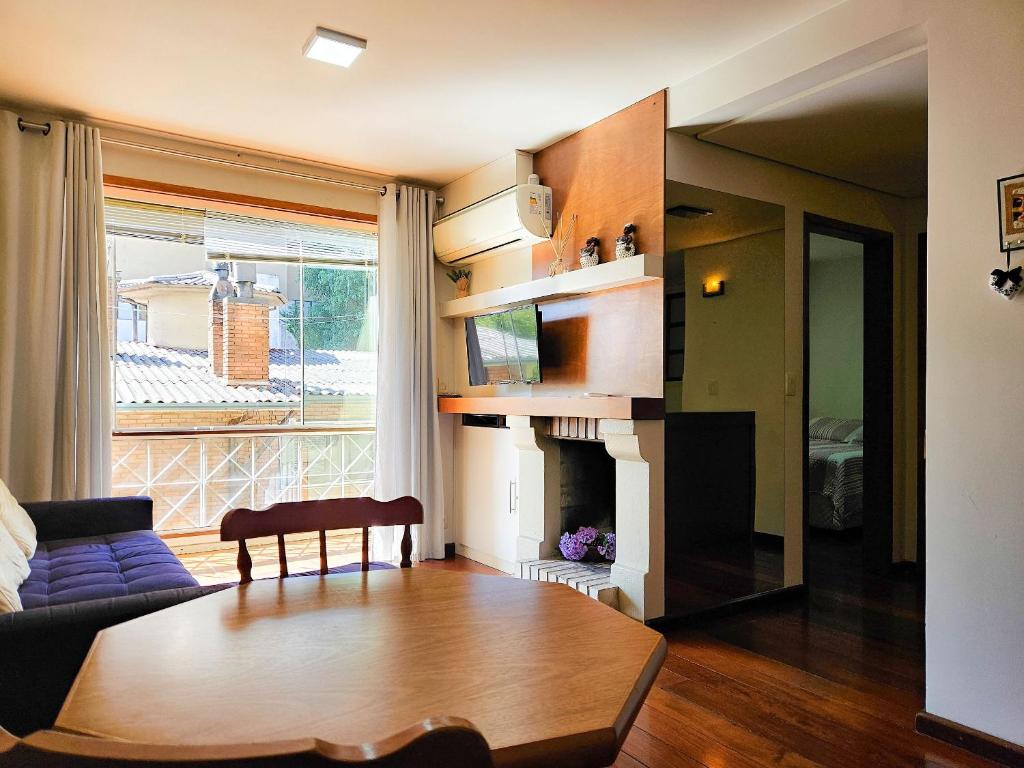 a living room with a couch and a fireplace at Saint Moritz 204 a 2 quadras da Rua Coberta in Gramado