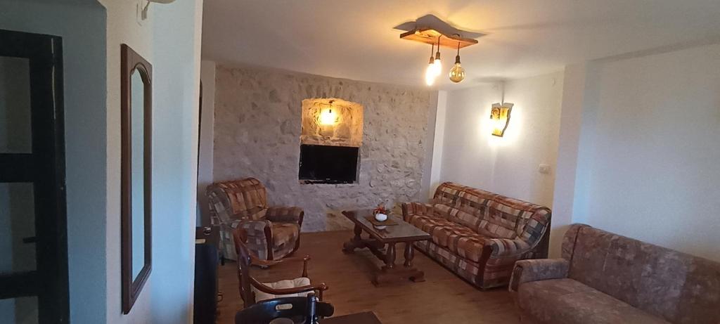 a living room with chairs and a couch and a table at Rustic house in Bar