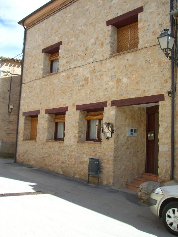 a brick building with windows and a car parked in front at Casa Rural Villa Kora in El Burgo de Osma