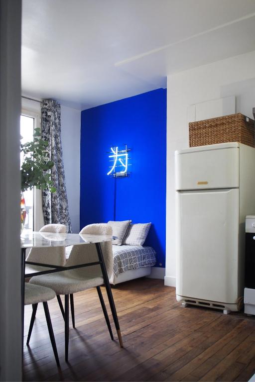 - un salon bleu avec une table et un canapé dans l'établissement Charmant deux pièces au coeur du Marais, à Paris