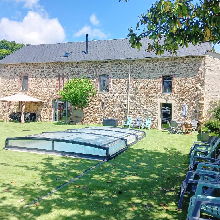ein Steinhaus mit einem Pool davor in der Unterkunft Gîte de la Duranderie in Sevremont