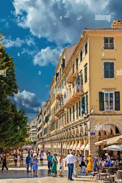 a group of people walking down a street with buildings at Liston Suites in Corfu