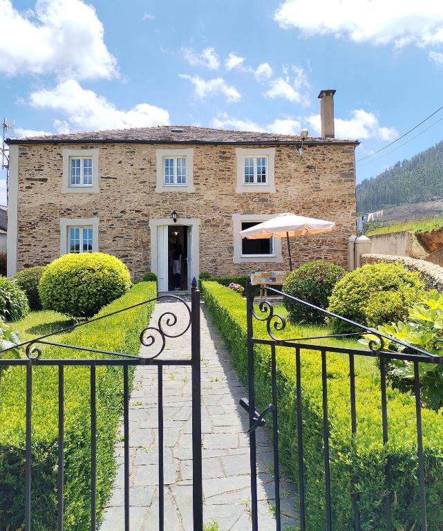 a stone house with an umbrella in front of it at Casa Lolita 1 in Viveiro