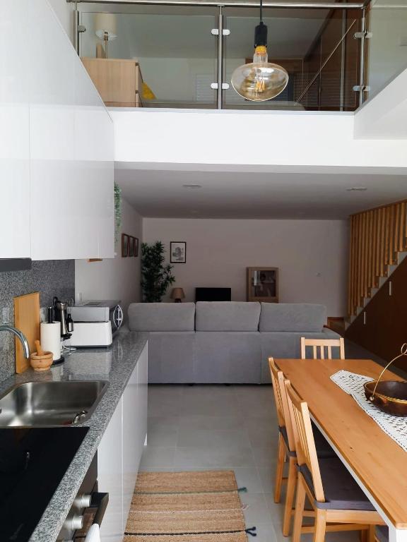 a kitchen and living room with a table and a couch at A Toca dos Coelhos in Mogadouro