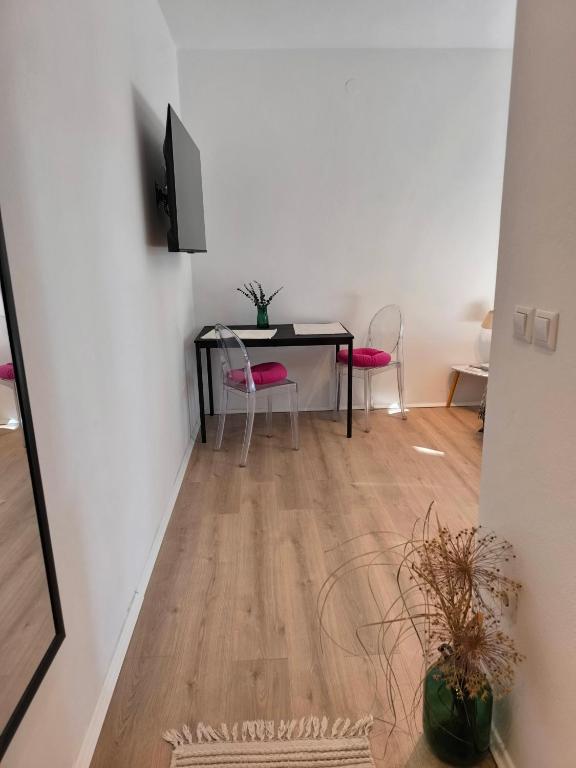 jadalnia ze stołem i różowymi krzesłami w obiekcie Apartment and Rooms Vilma w Fažanie