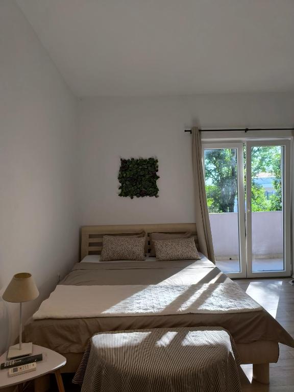 duże łóżko w pokoju z oknem w obiekcie Apartment and Rooms Vilma w Fažanie
