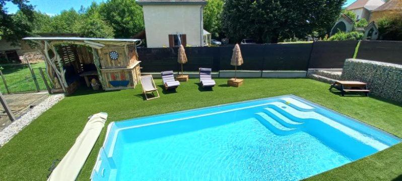 - une piscine dans une cour avec 2 chaises longues dans l'établissement Maison neuve proche station de ski, 10 couchages, tout confort, à Granieu