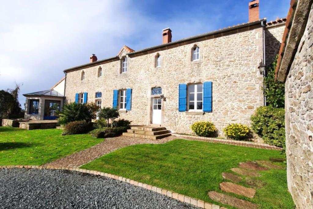 Cette grande maison en pierre est dotée de volets bleus. dans l'établissement La Durandière, à Le Puy-Saint-Bonnet