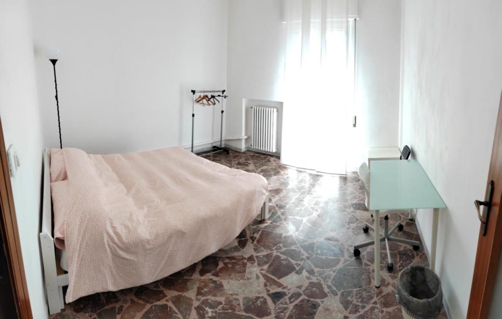 a room with a bed and a table and a window at White house in Bari