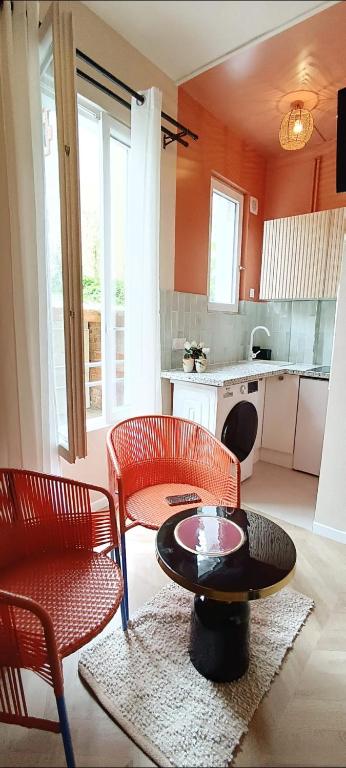 - une cuisine avec deux chaises et une table dans une chambre dans l'établissement Studio La CASITA COZY- la Défense - Paris St lazare, à Colombes