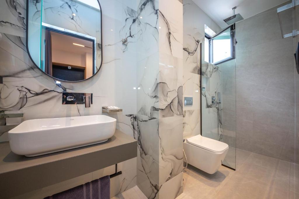 a bathroom with a sink and a toilet and a mirror at Vila Olserd Shehu in Ksamil