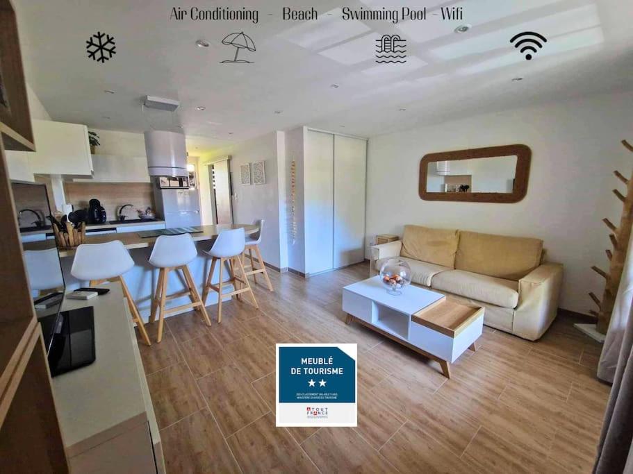 un salon avec un canapé et une table dans l'établissement Hameau des pins - Plage - Piscine - Wifi - Clim, à Saint-Raphaël