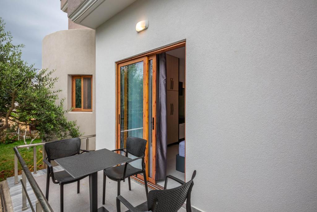 a balcony with chairs and a table and a window at Vila Olserd Shehu in Ksamil