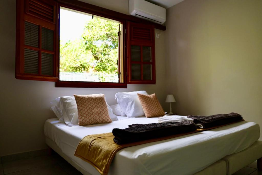 - une chambre avec un lit blanc et une fenêtre dans l'établissement Piscine, Plages Bois Jolan et du bourg, Jardin & Parking privés, Sainte-Anne - Villas Orchyd & Ka, à Sainte-Anne