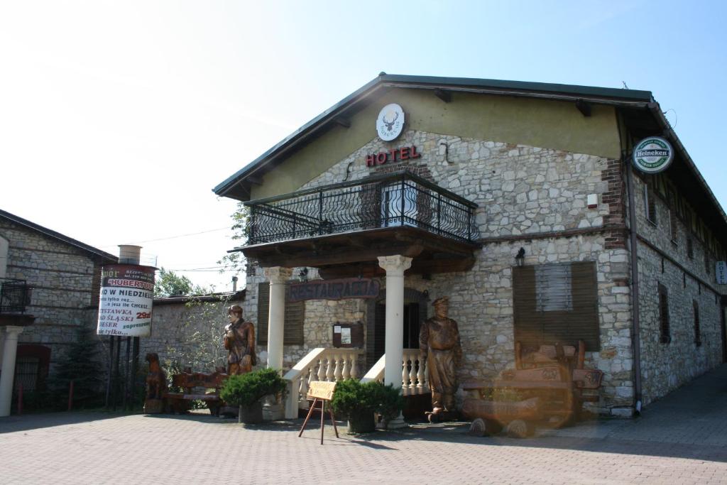 an old stone building with a balcony on it at Hotel Komfort Inn - Dwór Hubertus in Piekary Śląskie