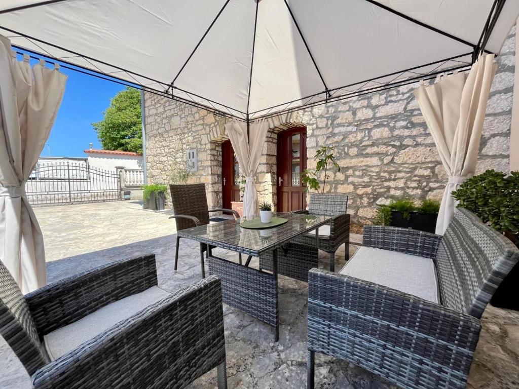 a patio with a table and chairs under a tent at Stone House Mia in Premantura