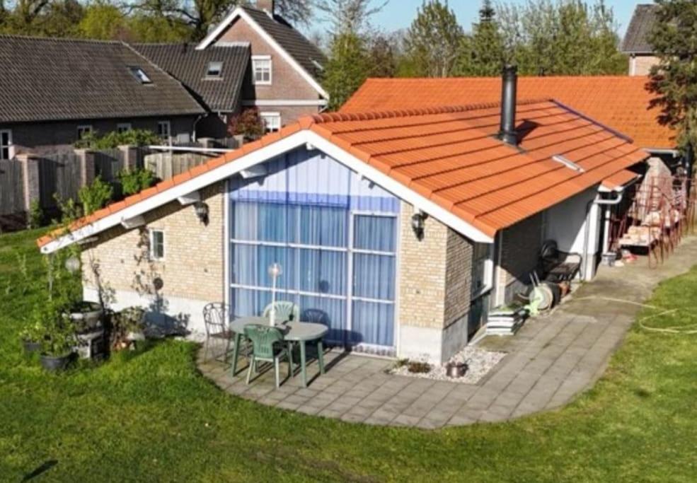 a house with an orange roof with a patio at BoerenBuiten De Brakke 1 in Vorstenbosch
